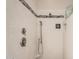 Bathroom with white tiled walls and a shower with a shower head and mounted TV at 15480 W Corrine Dr, Surprise, AZ 85379