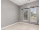 Bright bedroom featuring light gray walls, tile floors, and windows with stylish, arched decor above them at 15480 W Corrine Dr, Surprise, AZ 85379