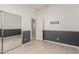 Bedroom featuring tiled floor, gray wainscoting, white walls, and mirrored closet doors at 15480 W Corrine Dr, Surprise, AZ 85379