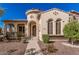 Charming home exterior featuring a unique turret entrance, arched windows, and well-maintained landscaping at 15480 W Corrine Dr, Surprise, AZ 85379