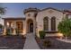 Charming home exterior featuring a unique turret entrance, arched windows, and well-maintained landscaping at 15480 W Corrine Dr, Surprise, AZ 85379