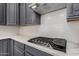 Close-up of a kitchen featuring quartz countertops, stainless steel appliances, and stylish subway tile backsplash at 15480 W Corrine Dr, Surprise, AZ 85379