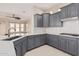 Modern kitchen featuring sleek gray cabinets, quartz countertops, and stainless steel appliances at 15480 W Corrine Dr, Surprise, AZ 85379