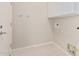 Clean laundry room with white cabinets and tile flooring at 15480 W Corrine Dr, Surprise, AZ 85379