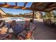 Relaxing poolside patio with comfortable seating under a pergola, overlooking a sparkling community pool and clubhouse at 15480 W Corrine Dr, Surprise, AZ 85379