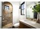 Modern bathroom with a stone shower, granite countertop, and a decorative vanity at 19978 N 101St Pl, Scottsdale, AZ 85255