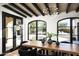 Dining room showcasing views of the outdoor pool area through black framed windows at 19978 N 101St Pl, Scottsdale, AZ 85255