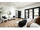 A bright primary bedroom with black French doors leading to the outdoor living area at 19978 N 101St Pl, Scottsdale, AZ 85255