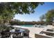 Relaxing poolside patio area features travertine flooring and outdoor seating under mature trees at 19978 N 101St Pl, Scottsdale, AZ 85255