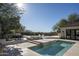 Backyard pool and dining area with waterfall feature, outdoor kitchen, and distant mountain views at 19978 N 101St Pl, Scottsdale, AZ 85255