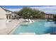 Inviting backyard pool with lounge chairs, a built-in grill, and lush landscaping, perfect for outdoor entertaining at 19978 N 101St Pl, Scottsdale, AZ 85255