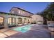 Backyard view featuring pool, outdoor kitchen and covered walkway against an exterior elevation at dusk at 19978 N 101St Pl, Scottsdale, AZ 85255