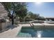 Backyard pool and outdoor kitchen view showing sparkling water and desert foliage under bright sun at 19978 N 101St Pl, Scottsdale, AZ 85255