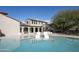 A stunning pool view showcasing the home's architecture, covered patio, and outdoor kitchen amenities at 19978 N 101St Pl, Scottsdale, AZ 85255