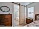 Bedroom featuring a sliding barn door that opens to an en suite bathroom with wood look tile flooring at 20231 W Grant St, Buckeye, AZ 85326