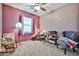 Cozy bedroom featuring carpeted floors, ceiling fan, and playful decor, creating a welcoming and comfortable space at 20231 W Grant St, Buckeye, AZ 85326