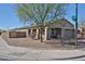 Corner lot home featuring desert landscaping, a covered porch, and mature trees for added curb appeal at 20231 W Grant St, Buckeye, AZ 85326