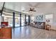 Bright living room with wood floors, large sliding glass doors, ceiling fan, and comfortable furniture at 20231 W Grant St, Buckeye, AZ 85326