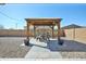 Patio with gravel landscaping featuring a charming pergola and outdoor dining set at 20231 W Grant St, Buckeye, AZ 85326