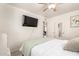 Bedroom with wood floors, light walls, a ceiling fan and mounted TV at 2032 E Harvard St, Phoenix, AZ 85006