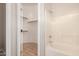 Bathroom showing a tub-shower and the door to a walk-in closet with wooden shelving at 2150 E Bell Rd # 1176, Phoenix, AZ 85022