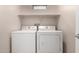 Bright laundry room with a white washer and dryer, plus a shelf above at 2150 E Bell Rd # 1176, Phoenix, AZ 85022