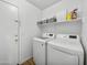 Well-lit laundry room featuring a modern washer and dryer, plus a storage shelf, and exterior door at 22336 E Via Del Palo --, Queen Creek, AZ 85142