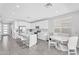 Modern kitchen with white cabinets, stainless appliances, an island with bar seating, and a round white breakfast table at 22484 E Twilight Dr, Queen Creek, AZ 85142