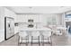 Bright, open kitchen with white cabinetry, stainless steel appliances, and a large quartz island with seating at 22484 E Twilight Dr, Queen Creek, AZ 85142