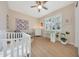 Bright Bedroom with a crib, desk, and a window with plantation shutters at 24117 N 165Th Dr, Surprise, AZ 85387