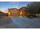 Charming single-Gathering home featuring a stone entrance, two-car garage, and well-manicured landscaping at 24117 N 165Th Dr, Surprise, AZ 85387