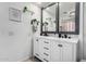 Bathroom with dual sinks, white cabinetry, black fixtures, and elegant mirrors at 2435 W Via Dona Rd, Phoenix, AZ 85085