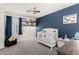 Charming Bedroom with a white crib, blue accent wall, and plush toys, creating a cozy and inviting space at 2435 W Via Dona Rd, Phoenix, AZ 85085