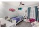 Lovely bedroom with a twin bed, cute decor, a ceiling fan, and natural light from the shuttered window at 2435 W Via Dona Rd, Phoenix, AZ 85085