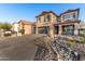 Two-story home features a wide driveway and xeriscaped yard with desert landscaping, and a covered porch at 2435 W Via Dona Rd, Phoenix, AZ 85085