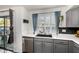 Modern kitchen with gray cabinets, stainless steel dishwasher, and black sink under a window at 2435 W Via Dona Rd, Phoenix, AZ 85085