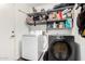 Functional laundry room with modern washer and dryer units, plus ample shelving for storage and organization at 2435 W Via Dona Rd, Phoenix, AZ 85085