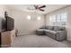 Cozy living room with neutral walls, carpet, ceiling fan and a comfortable gray sectional sofa at 2435 W Via Dona Rd, Phoenix, AZ 85085