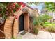 Property's entrance with brick archway with security door, decorative climbing vines, and well-kept garden at 3046 N 32Nd St # 328, Phoenix, AZ 85018