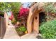 Property's entrance with brick archway with security door, decorative climbing vines, and well-kept garden at 3046 N 32Nd St # 328, Phoenix, AZ 85018