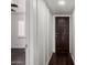 Bright hallway featuring wood-look floors and white walls with an open doorway to a secondary room with shuttered windows at 3046 N 32Nd St # 328, Phoenix, AZ 85018