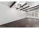 Spacious living room featuring dark wood-look floors, a beamed ceiling with ceiling fans, and shuttered windows at 3046 N 32Nd St # 328, Phoenix, AZ 85018