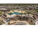 Aerial view of the community pool area with palm trees, shaded seating, and a clubhouse at 34997 N Sacramento Wash Rd, San Tan Valley, AZ 85144