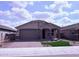 Charming single-story home featuring a brick driveway, two-car garage, and manicured front lawn at 34997 N Sacramento Wash Rd, San Tan Valley, AZ 85144