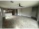 Spacious living room with modern tile flooring, large windows, and open layout to the kitchen area at 34997 N Sacramento Wash Rd, San Tan Valley, AZ 85144