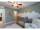 A cozy Bedroom with gold star wallpaper, crib, white rocker, and decorative wall design at 3507 E Jasper Dr, Gilbert, AZ 85296