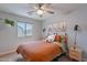 Bright bedroom with a large window and ceiling fan, complemented by desert-themed decor at 3507 E Jasper Dr, Gilbert, AZ 85296