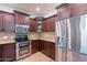 Kitchen features stainless steel appliances, wooden cabinets, and granite countertops at 3507 E Jasper Dr, Gilbert, AZ 85296