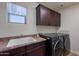 Functional laundry room with modern washer and dryer, ample counter space, and storage cabinets at 3507 E Jasper Dr, Gilbert, AZ 85296