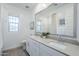 Bright bathroom featuring double sinks, framed mirror, and natural light from the window at 4077 S Sabrina Dr # 138, Chandler, AZ 85248